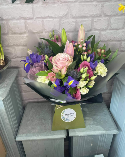 Enchanted Pastel Harmony - A beautifully balanced arrangement that blends soft pastel tones with vibrant accents for a truly enchanting display. Gentle blush hues are complemented by pops of rich purples and fresh greens, creating depth and visual intrigue. Layered textures and graceful lines give this piece a natural, garden-inspired feel while maintaining a polished, modern presentation. Perfect for heartfelt occasions or as a thoughtful gesture, this design brings a sense of elegance, charm, and quiet sophistication to any space.