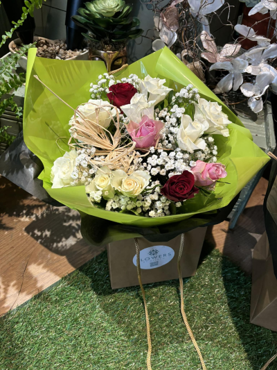 Rose Romance - A charming and expressive arrangement that blends soft elegance with vibrant contrast. Delicate blush and creamy tones are beautifully paired with rich, deeper accents, all nestled among airy clusters and fresh greenery. The bright wrap adds a modern, uplifting touch, while the natural textures create a soft, romantic feel. Perfect for heartfelt occasions or meaningful surprises, this design captures warmth, affection, and timeless beauty in one graceful display.